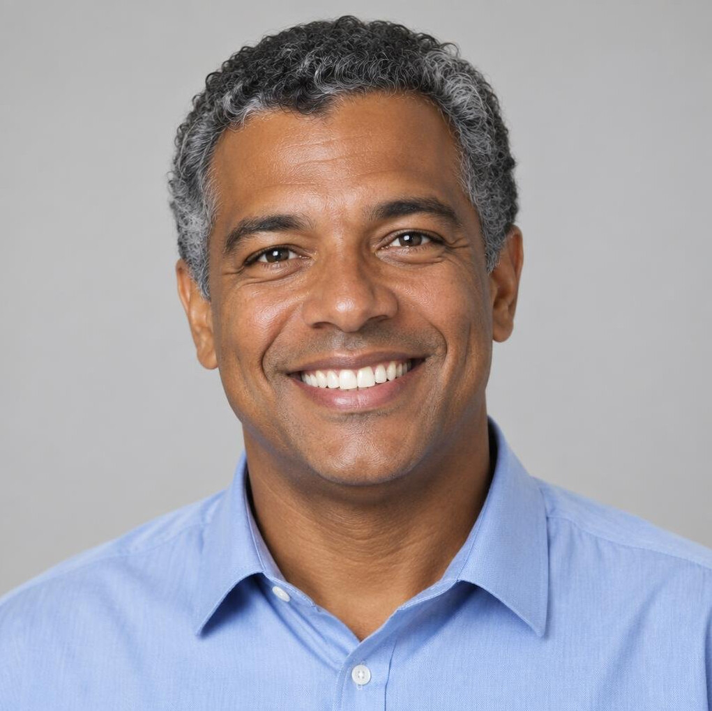 Brazilian man with curly hair smiling for a portrait