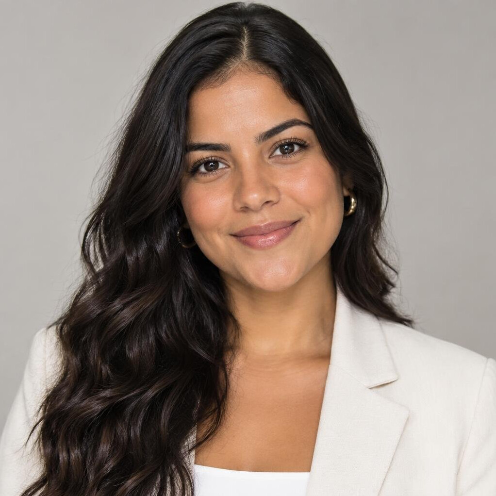 Brazilian woman with long wavy hair smiling for a portrait
