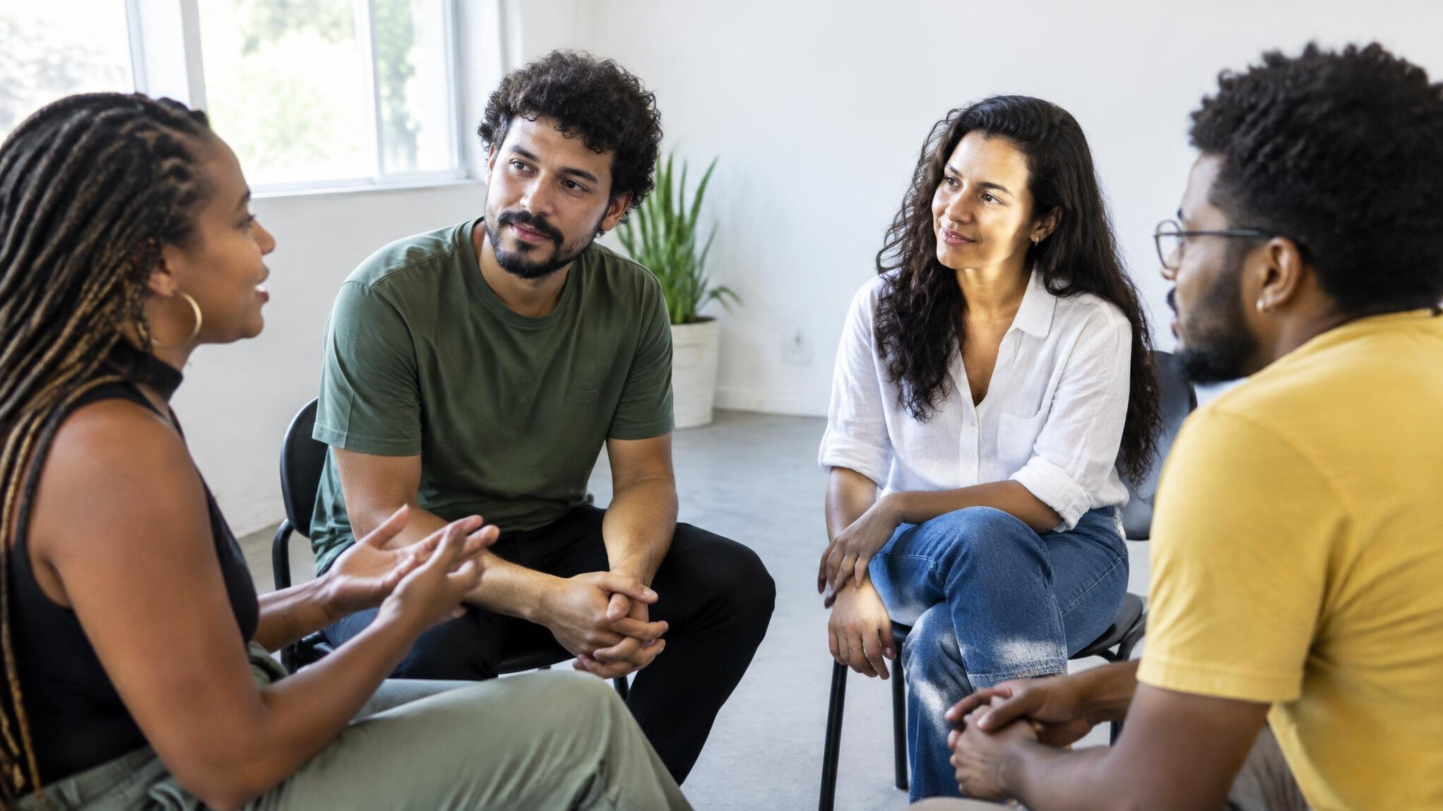 Small group of people having an open conversation in a bright room